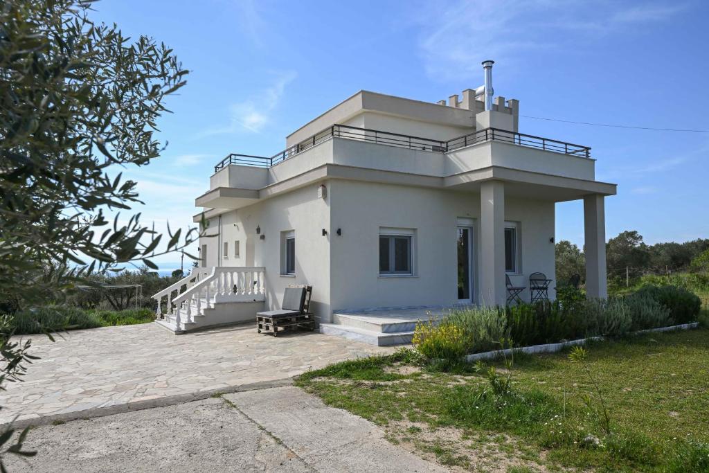 a white house with a balcony on a patio at Palataki in Epanomi