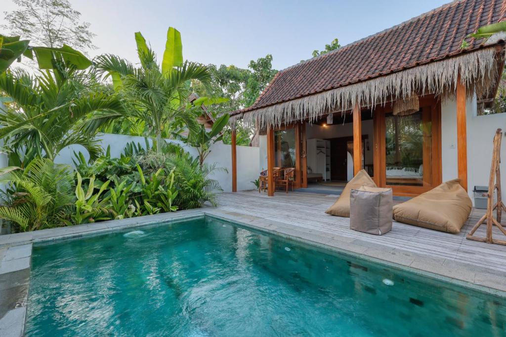 a villa with a swimming pool in front of a house at Bayrin Private Villas in Nusa Penida