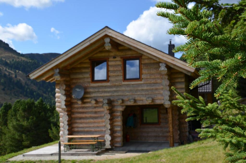 a log cabin on a hill with a tree at Ferner Alm in Thomatal