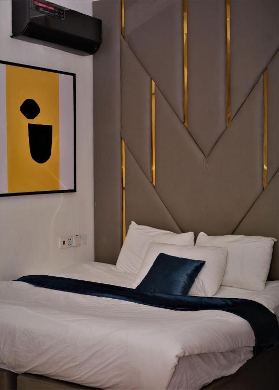 a bedroom with a large bed with white sheets at Top city Homes in Lagos