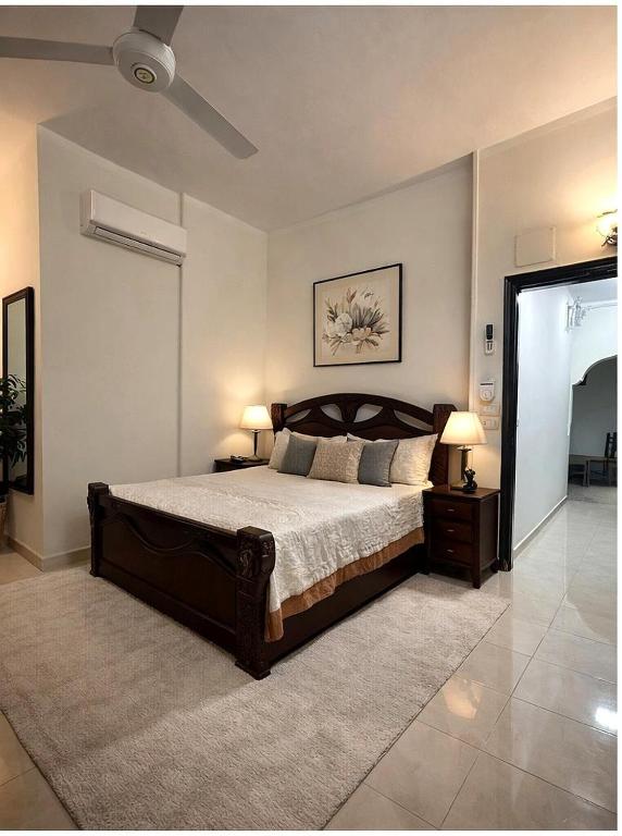 a bedroom with a large bed with two tables and two lamps at Luxor flats and apartments in Luxor
