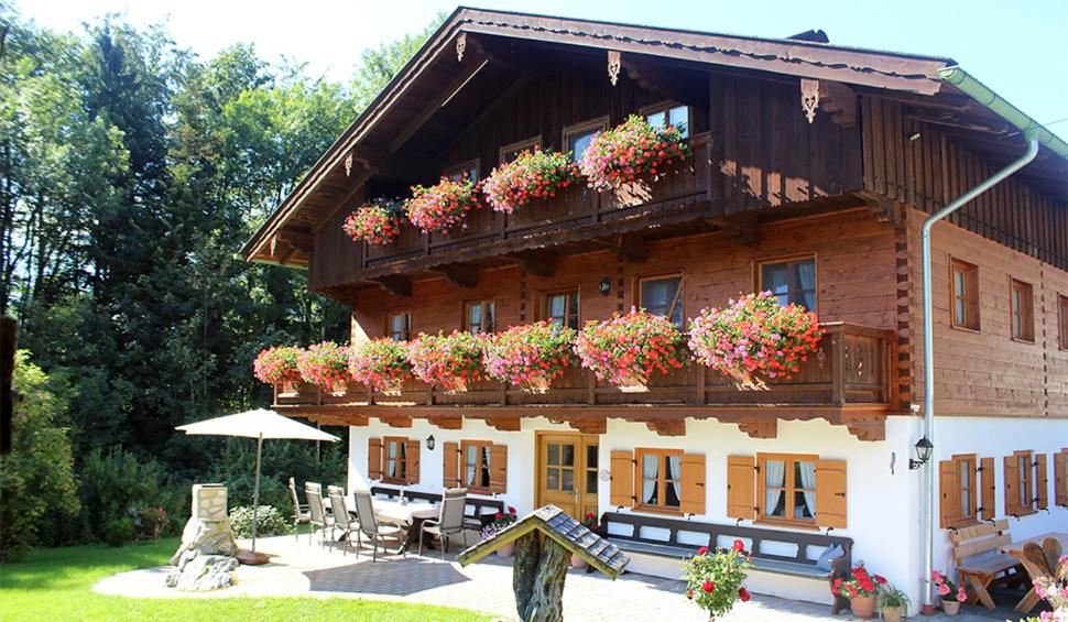 ein Gebäude mit Blumenkästen an der Seite in der Unterkunft Pension Gerstenbrand in Fischbachau