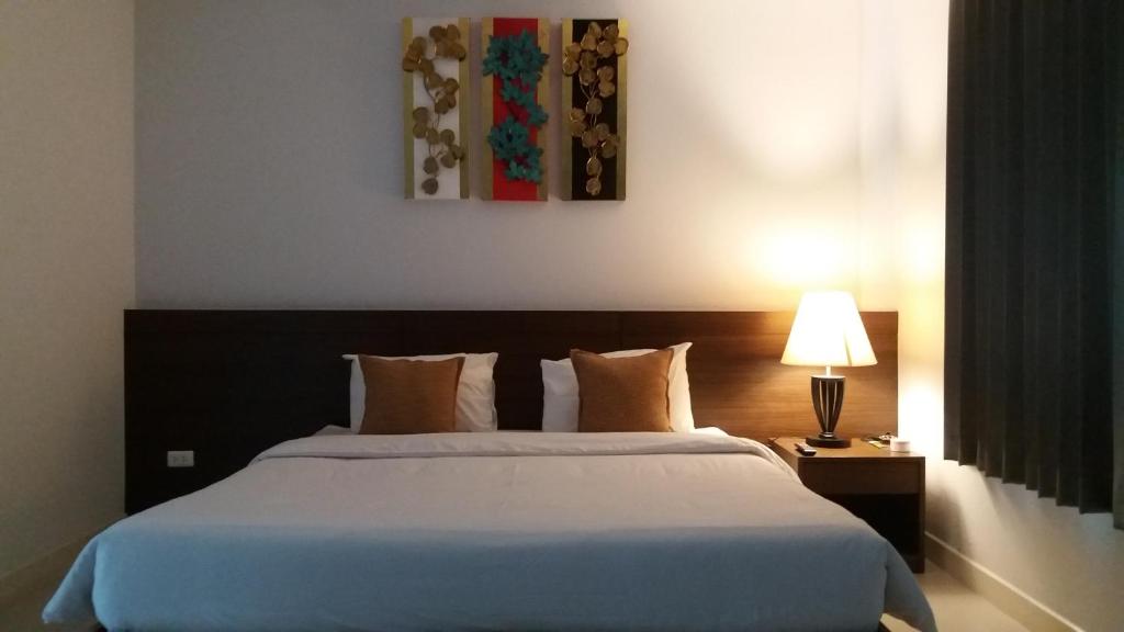 sypialnia z dużym białym łóżkiem i lampką w obiekcie Green House Phuket w mieście Ban Pa Khlok