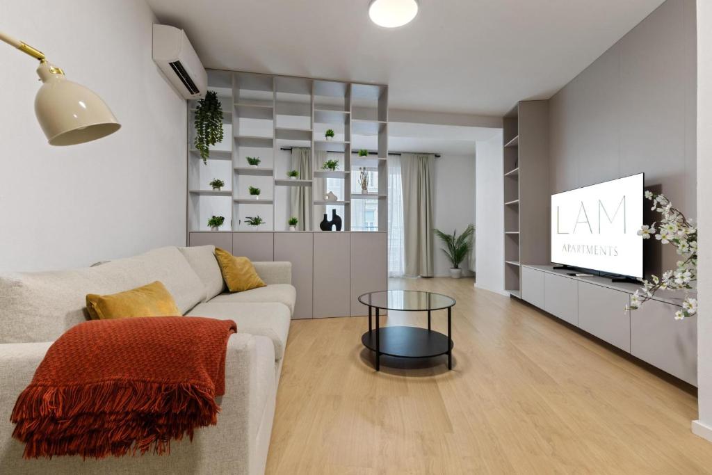 a living room with a couch and a tv at LAM Schon - AC in Bratislava