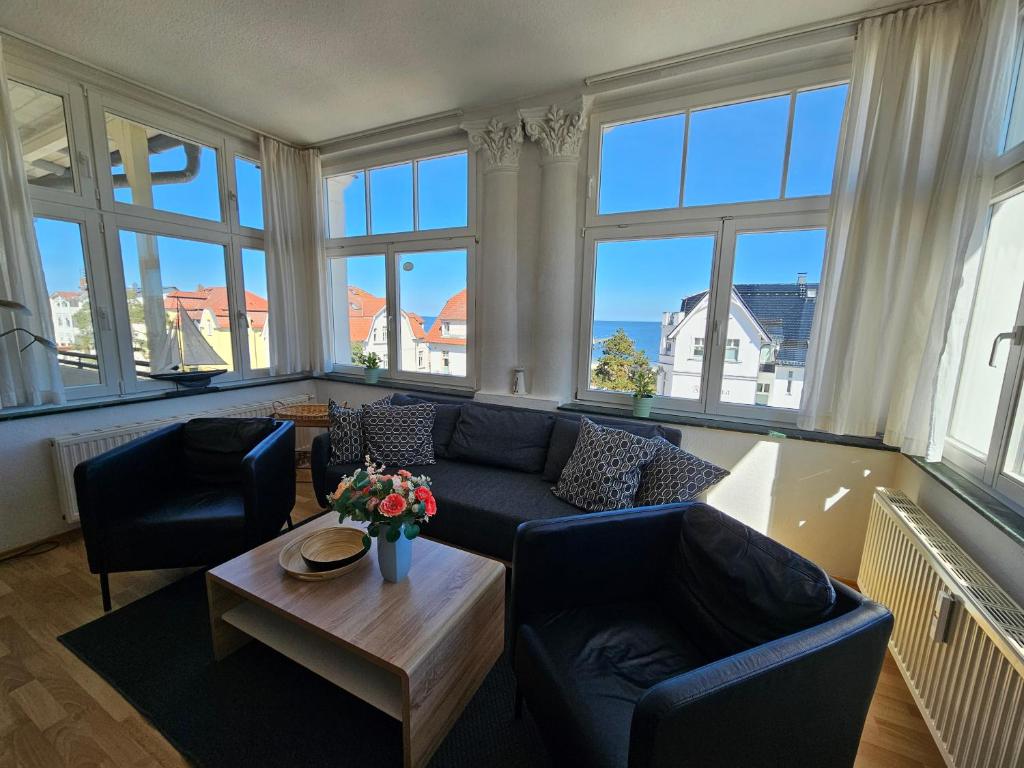 a living room with a couch and chairs and windows at Villa Kurfürst - 100 m zum Strand in Bansin