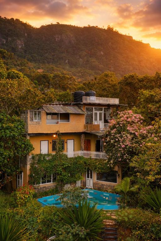 a large building with trees and a mountain at Shvaas Boutique Villa in Dambawelagama