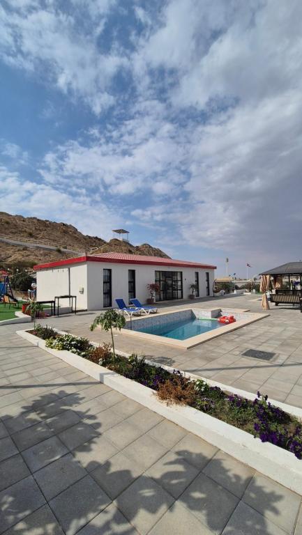 a building with a swimming pool in front of it at Noor-Hatta Deluxe Villa Farmhouse in Hatta