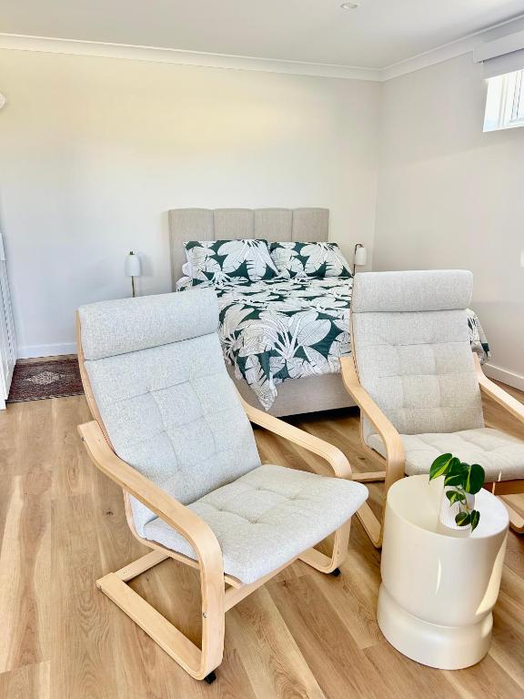 a bedroom with two chairs and a bed at La Porta Rosa in Bunbury