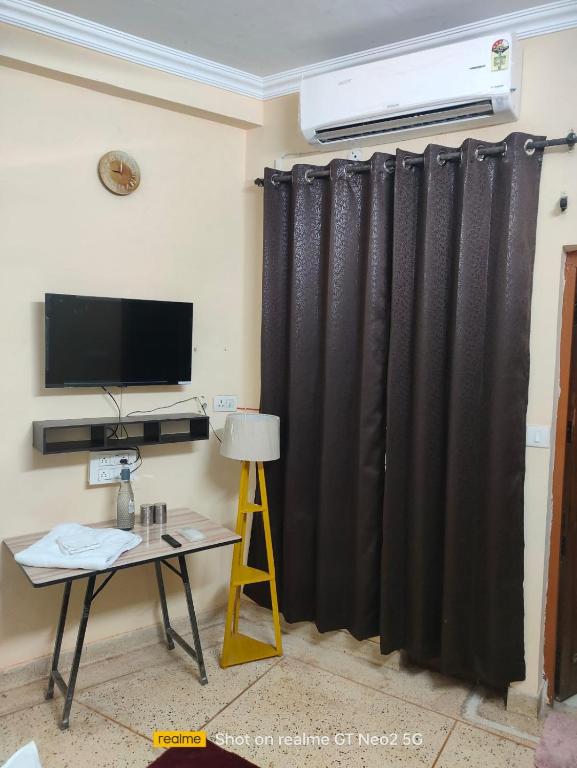 a living room with a black curtain and a table at Uma's Homestay in Gwalior