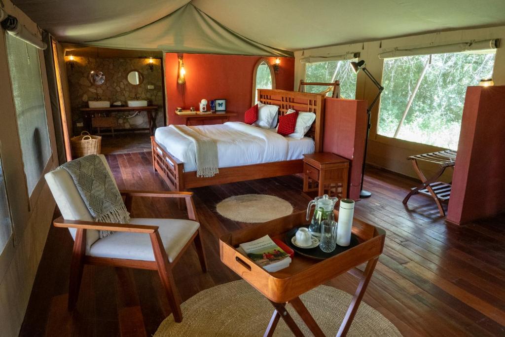 a bedroom in a tent with a bed and a table at Oreteti Mara Lodge in Lolgorien