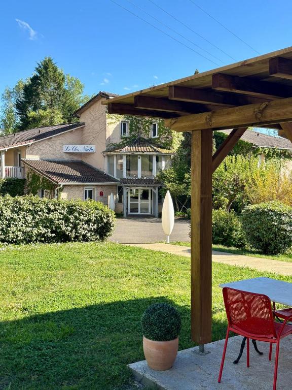 a patio with a table and chairs in front of a house at Le Clos Nicolas in Eugénie-les-Bains