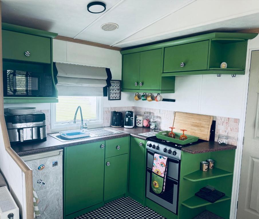 a kitchen with green cabinets and a stove at PGB by the Sea in Filey