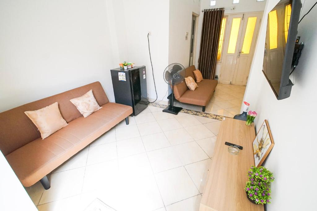 a living room with a couch and a television at Rayyan Homestay Jogja in Timuran