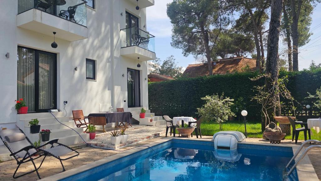 a house with a swimming pool in the yard at Poolside and Garden Apartments Golem Beach in Golem