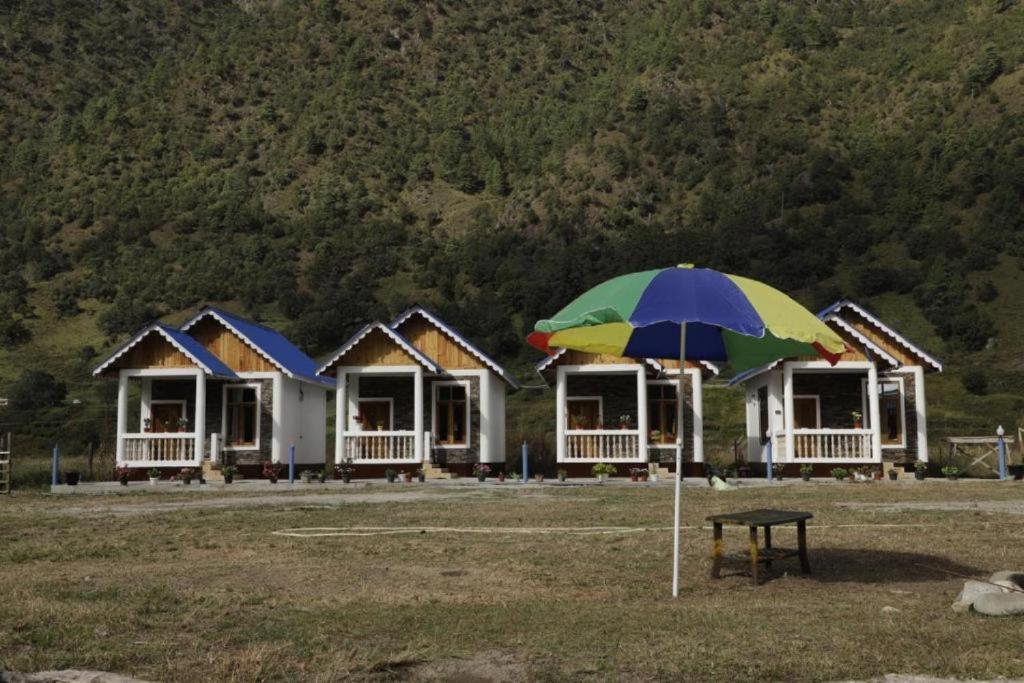 a umbrella in front of a row of houses at Sangti River Front Homestay in Dirang Dzong
