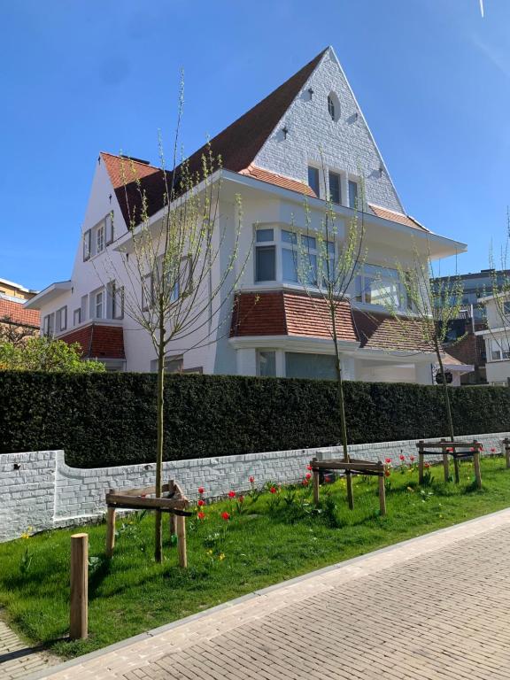 a group of benches in front of a house at Bed & Breakfast Esprit de Mer in De Panne
