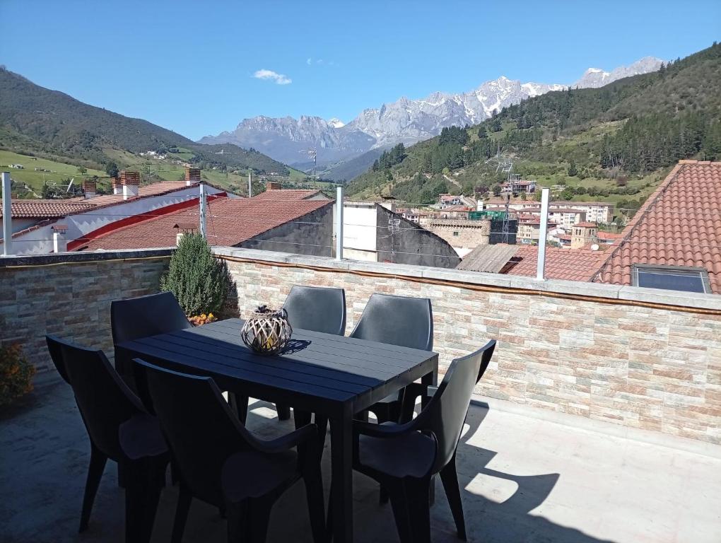 a table and chairs on a balcony with mountains at Casona MilaWen in Potes