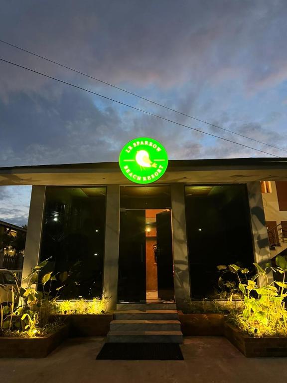 a fast food restaurant with a green sign on the building at Le Sparrow Beach- Rooms in Mangalore