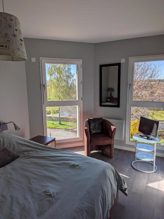 a bedroom with a bed and a desk with a laptop at La Naute in Saint-Paulien
