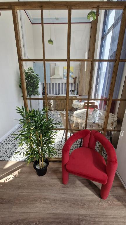 a red chair and a potted plant in a room at Hostel CAPS HOME boutique in Astana