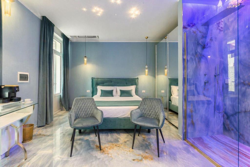 a bedroom with a bed and two chairs at Suite Acquamarine by Symphonya Luxury Holiday Rentals in Gallipoli