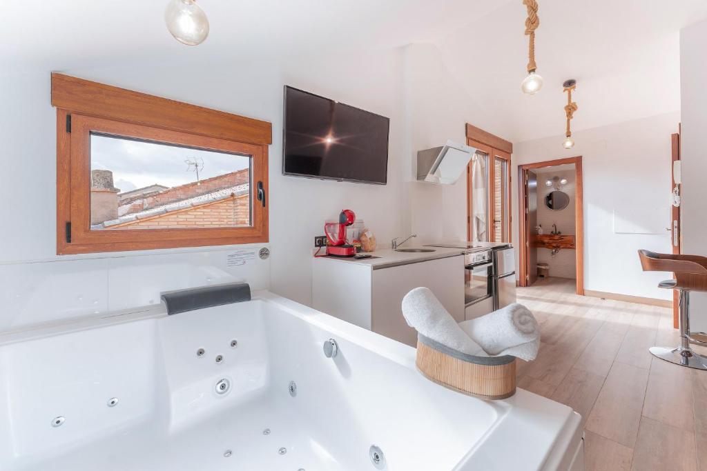 a large bathroom with a tub and a tv at ATICO El TRANCO in Villel