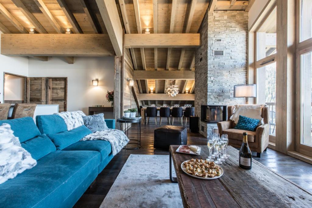 a living room with a blue couch and a table at Keystone Lodge by Alpine Residences in Courchevel