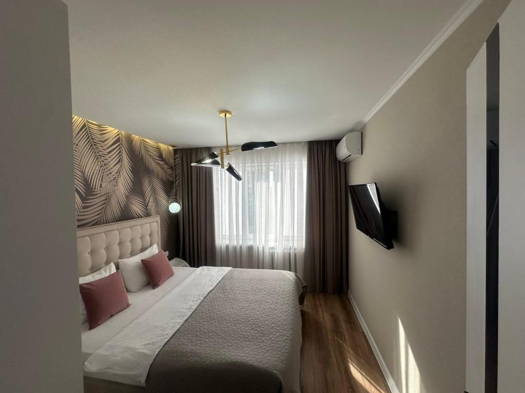 a hotel room with a bed and a window at Sweethome Riscani in Chişinău
