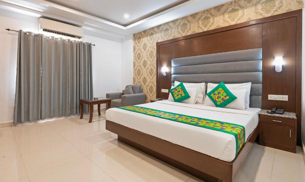 a hotel room with a bed and a desk and a chair at Treebo Premium Grand Legacy Elite with Roof Top Cafe in Dehradun