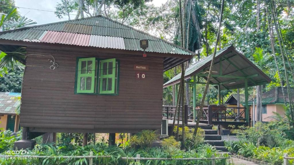 a small house with a green window and stairs at Ban Chomdoi บ้านชมดอย in Ban Dong