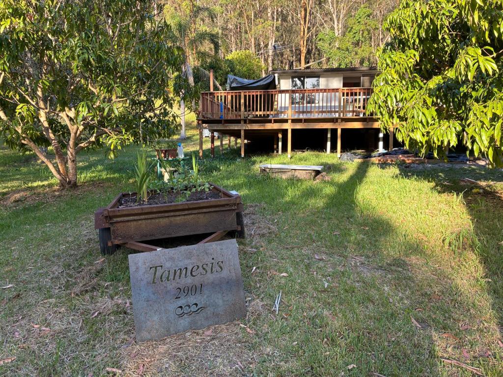 a house with a sign in the grass with a yard at Tamesis - Wildernest in Neranie
