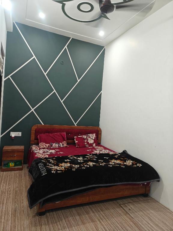 a bedroom with a bed with red sheets and a wall at Shri Ram Vila Guest House in Ayodhya