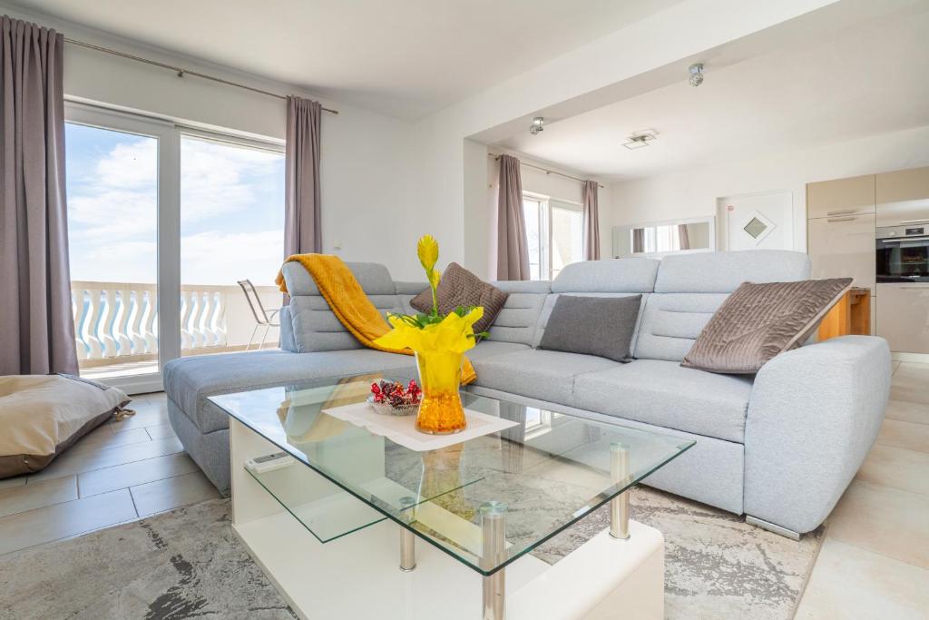 a living room with a blue couch and a glass table at Apartman D&D in Starigrad