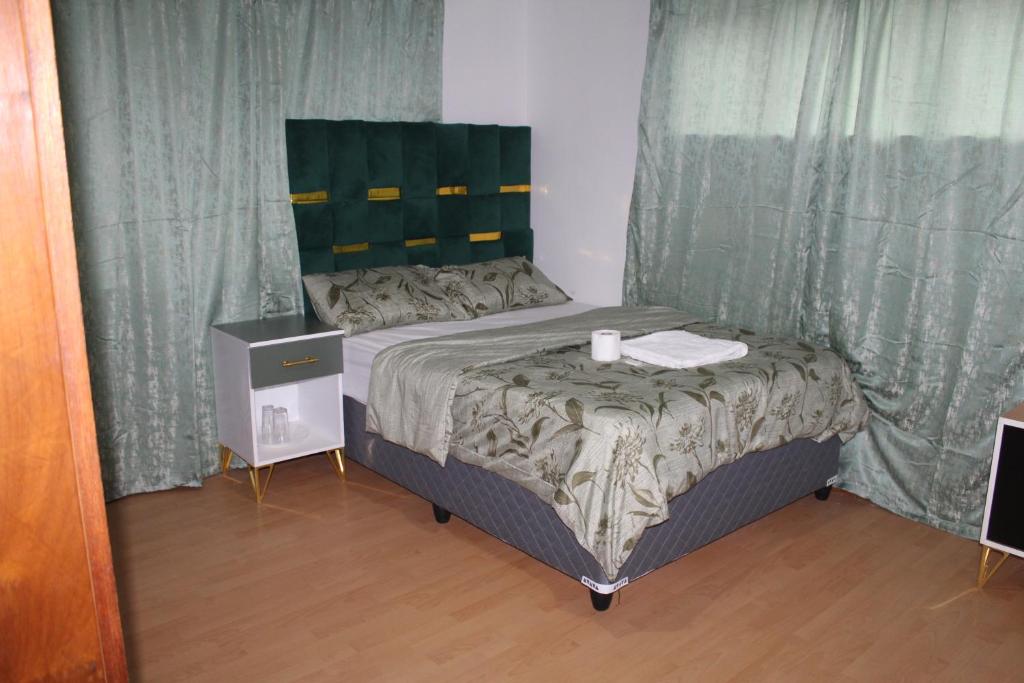 a small bed in a room with curtains at Tatami Guesthouse in Parow