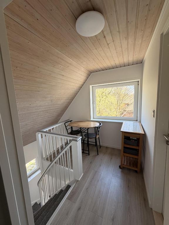 a room with a staircase and a table and a window at Harknakvej 19 BB in Bredebro