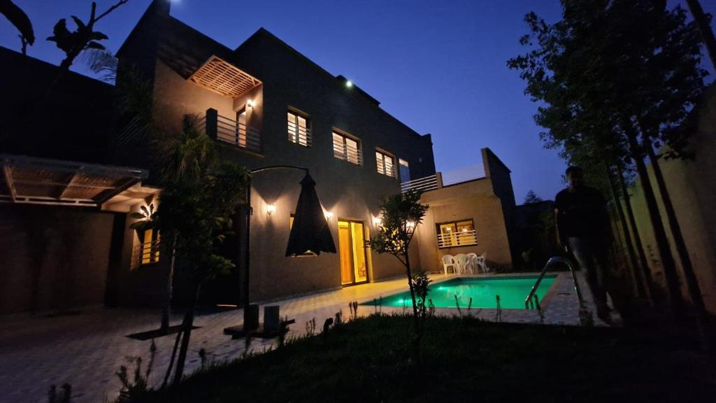 a house with a swimming pool at night at Villa Mazigh - 4 Bedrooms Villa with Pool in Marrakesh