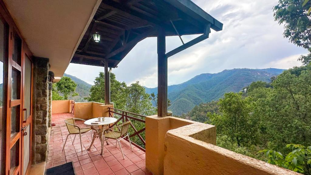 a balcony of a house with a table and chairs at Wild Meadows by Levitate - Exclusive Dual Bedroom Chalet Open Sky View & Fully Equipped Kitchen in Rāmgarh
