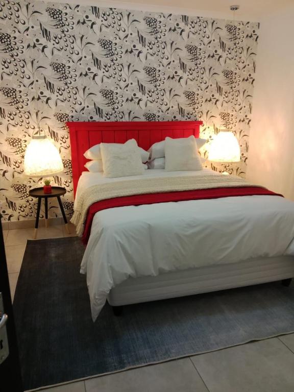 a bedroom with a large bed with a red headboard at Townside Estate UNIT8 in Ladysmith