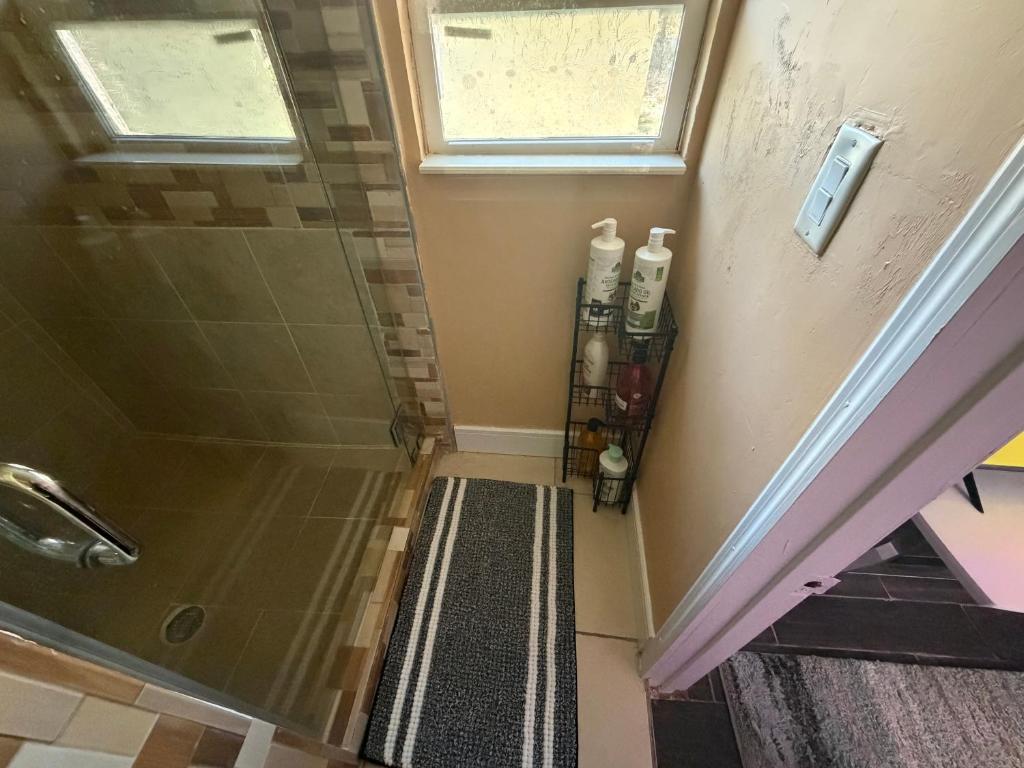 a bathroom with a shower with two bottles on the wall at Backyard Cottage in Naples
