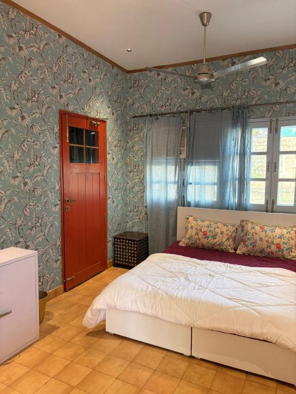 a bedroom with a bed and a red door at The Amar Vilas in Dehradun