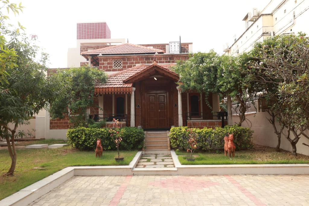 a house with two dogs standing in front of it at SIENNA Ecr in Chennai