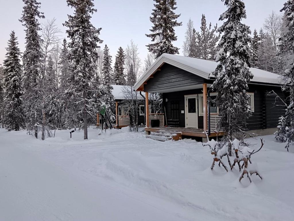 a cabin in the snow with snow covered trees at B&B Adventures in Äkäslompolo