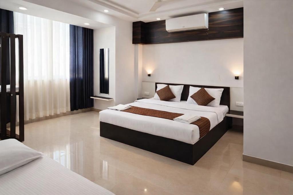 a bedroom with two beds in a hotel room at Sairaah Golden Suites, Shirdi in Shirdi