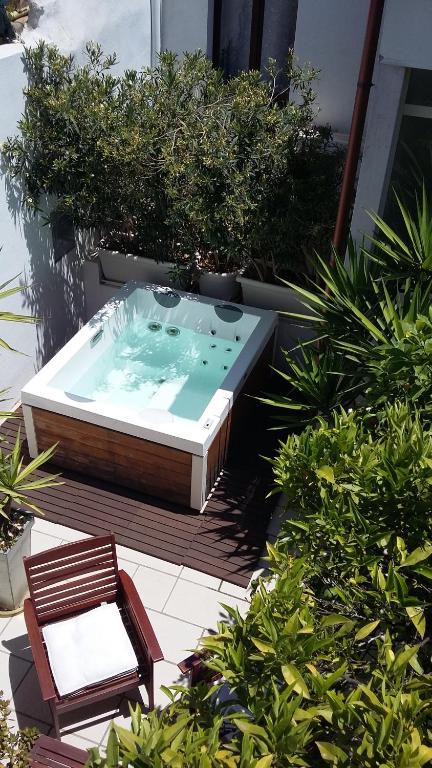 a hot tub with a chair in a garden at I'MC IoAMoCagliari in Cagliari