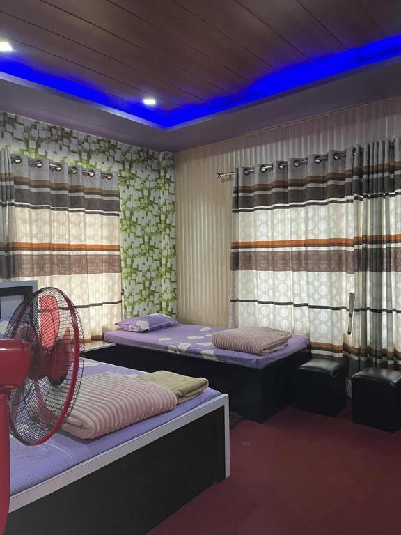 a room with two beds and a fan at Paradise Hotel & Lodge in Birtamod