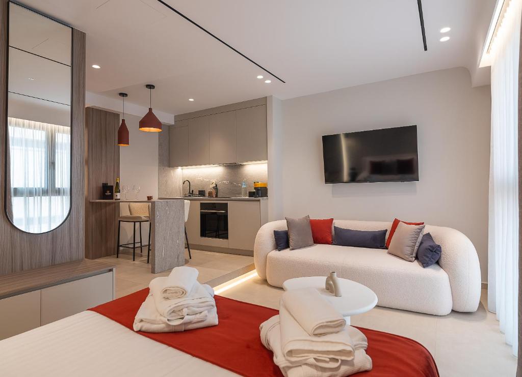 a living room with a couch and a kitchen at Space Row Exclusive Residences in Heraklio