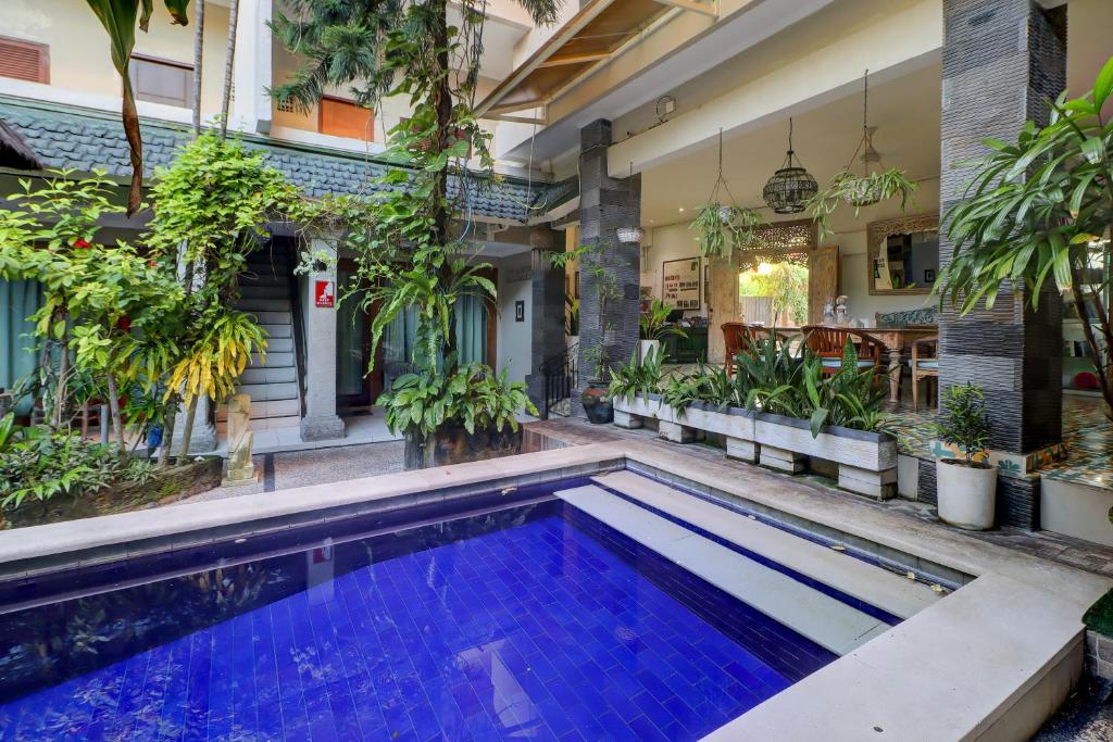 a swimming pool in a house with plants at Townhouse Oak Su's Cottage Near Legian Beach in Legian