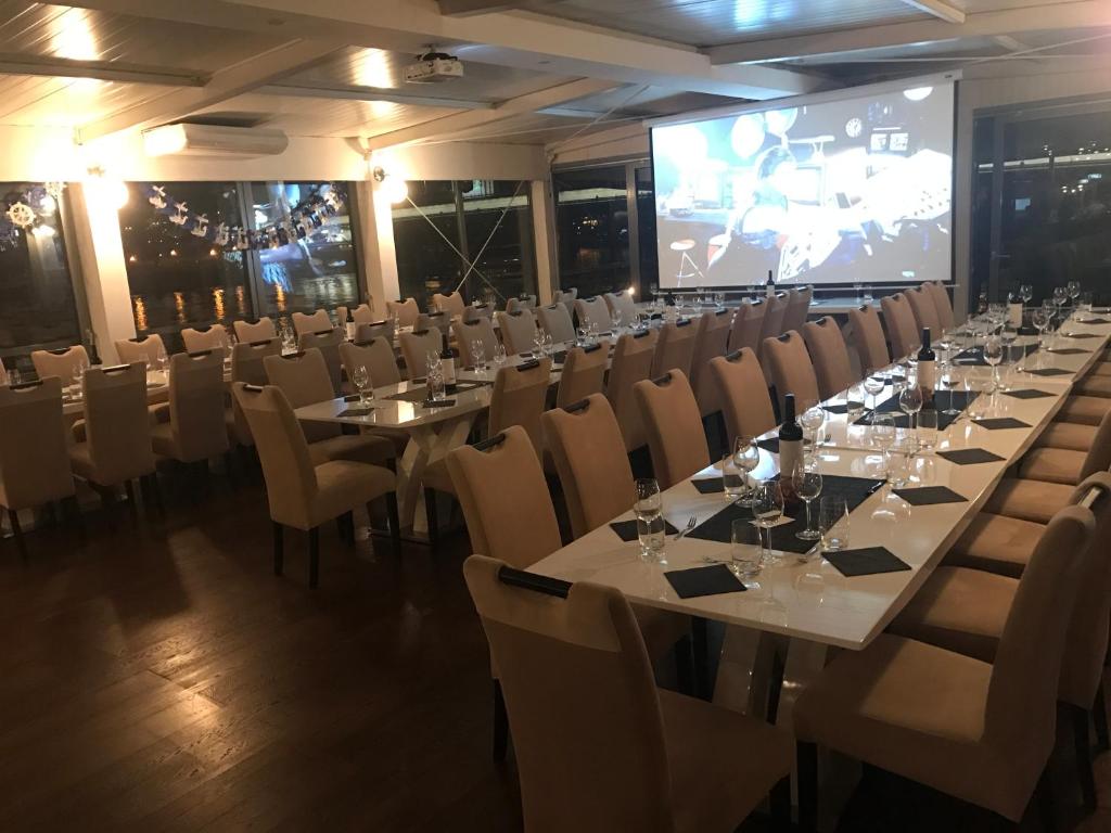 a conference room with tables and chairs and a screen at Botel Gracia in Bratislava