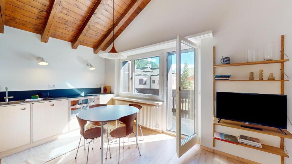 a kitchen with a table and chairs and a tv at Chesa Chatrigna App 9 - Celerina in Celerina