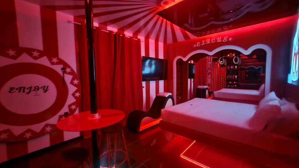 a red room with a bed and a tv at C rooms - Suite a tema con vasca - Motel Monza in Cinisello Balsamo
